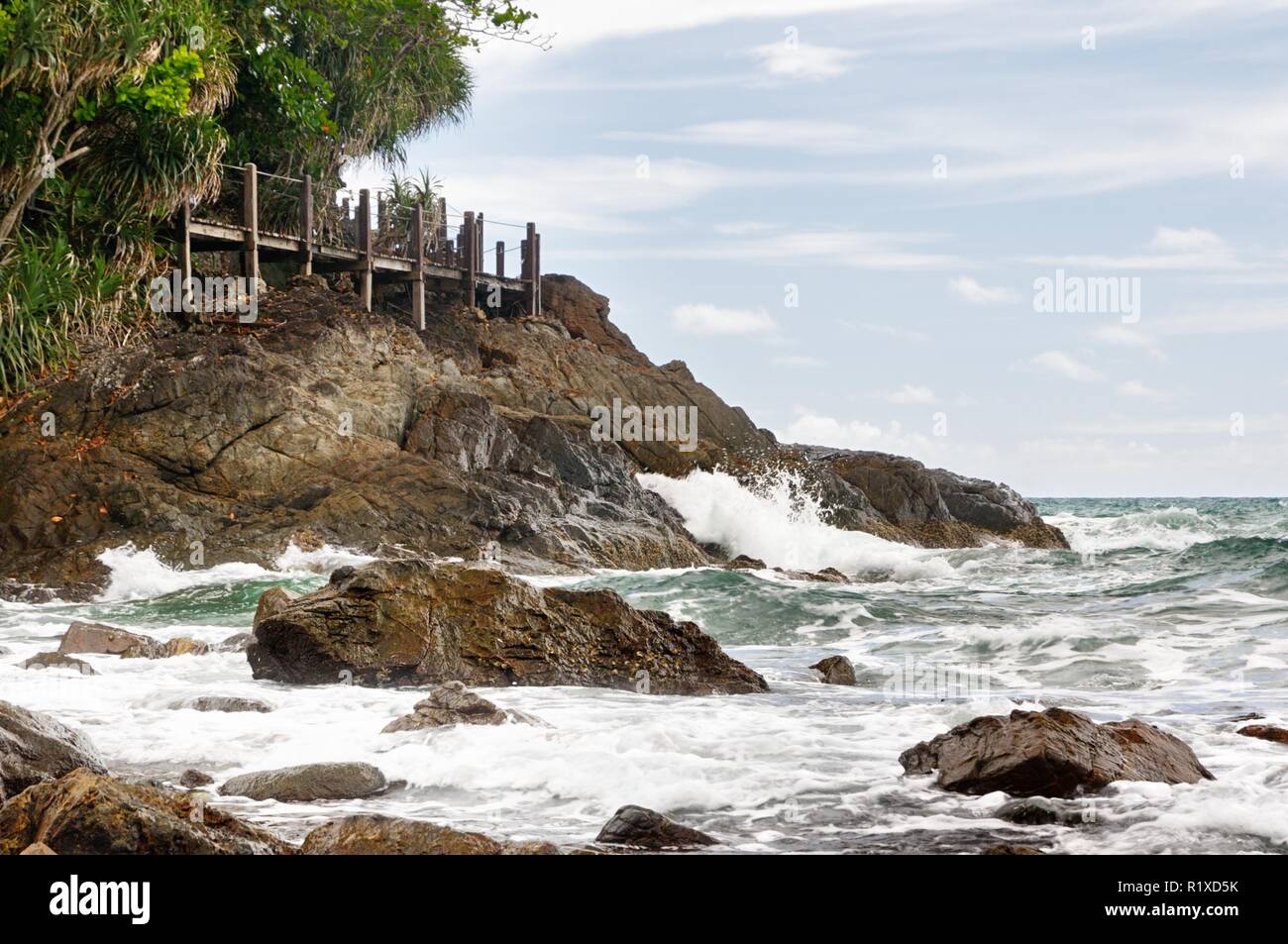 View of deserted rocky coastline and turquoise tropical storm sea with a surf on tropical Koh Chang island in Thailand Stock Photo
