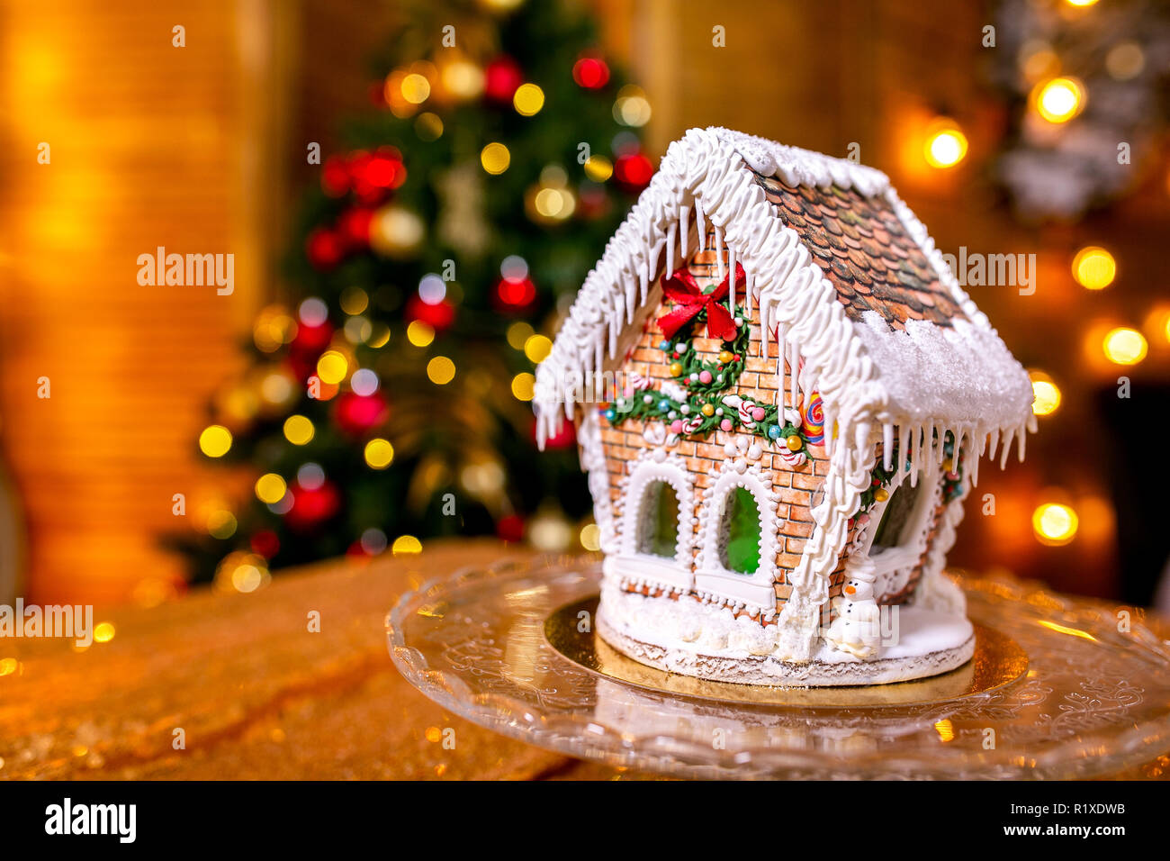 Gingerbread house in front of defocused lights of Christmas