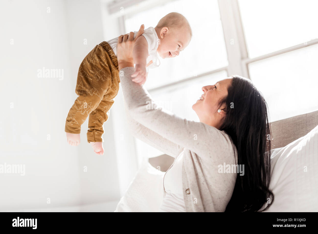 A woman with a baby on bed at home Stock Photo Alamy