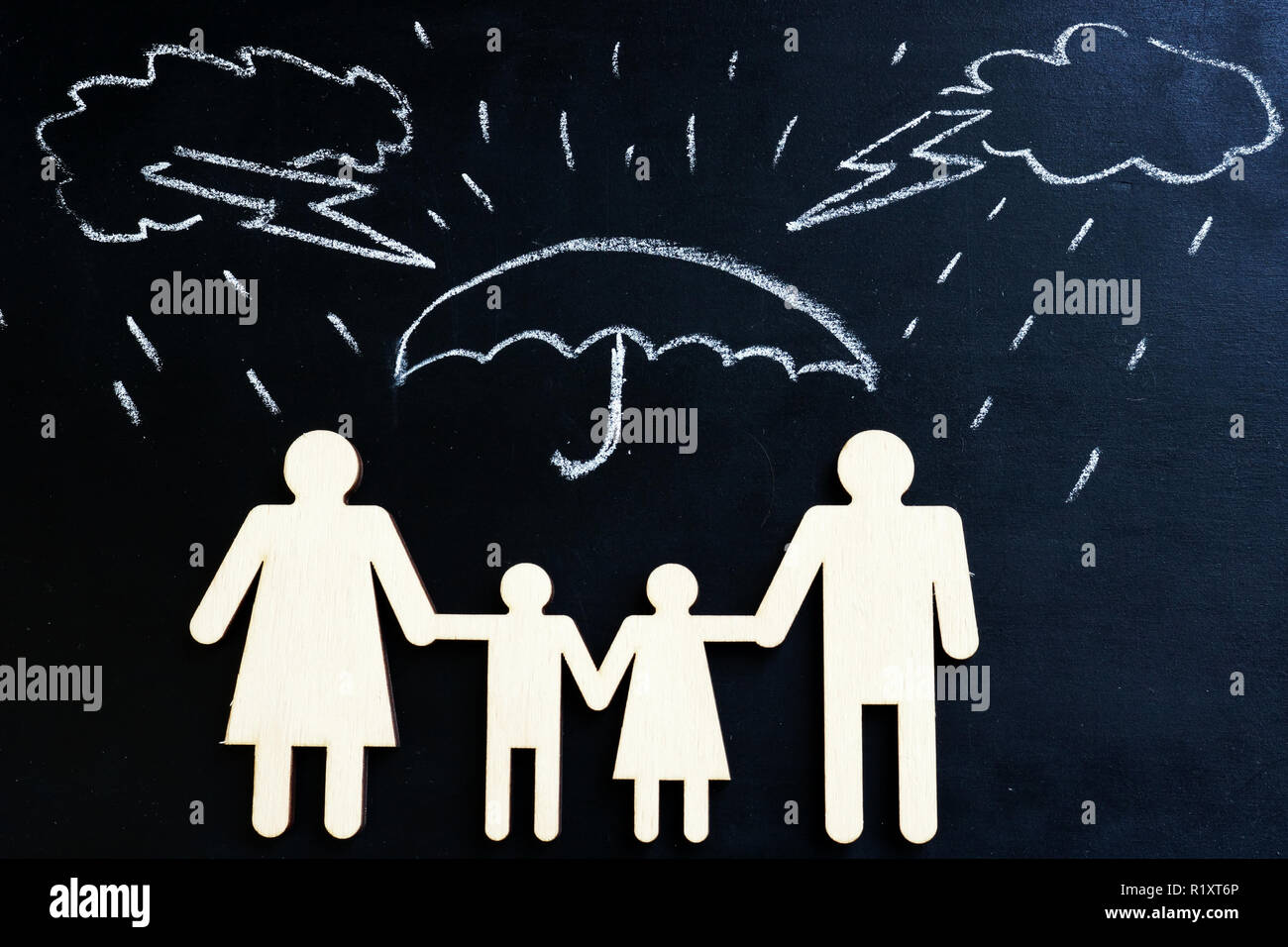 Life insurance. Drawn rain and family figures under umbrella. Stock Photo