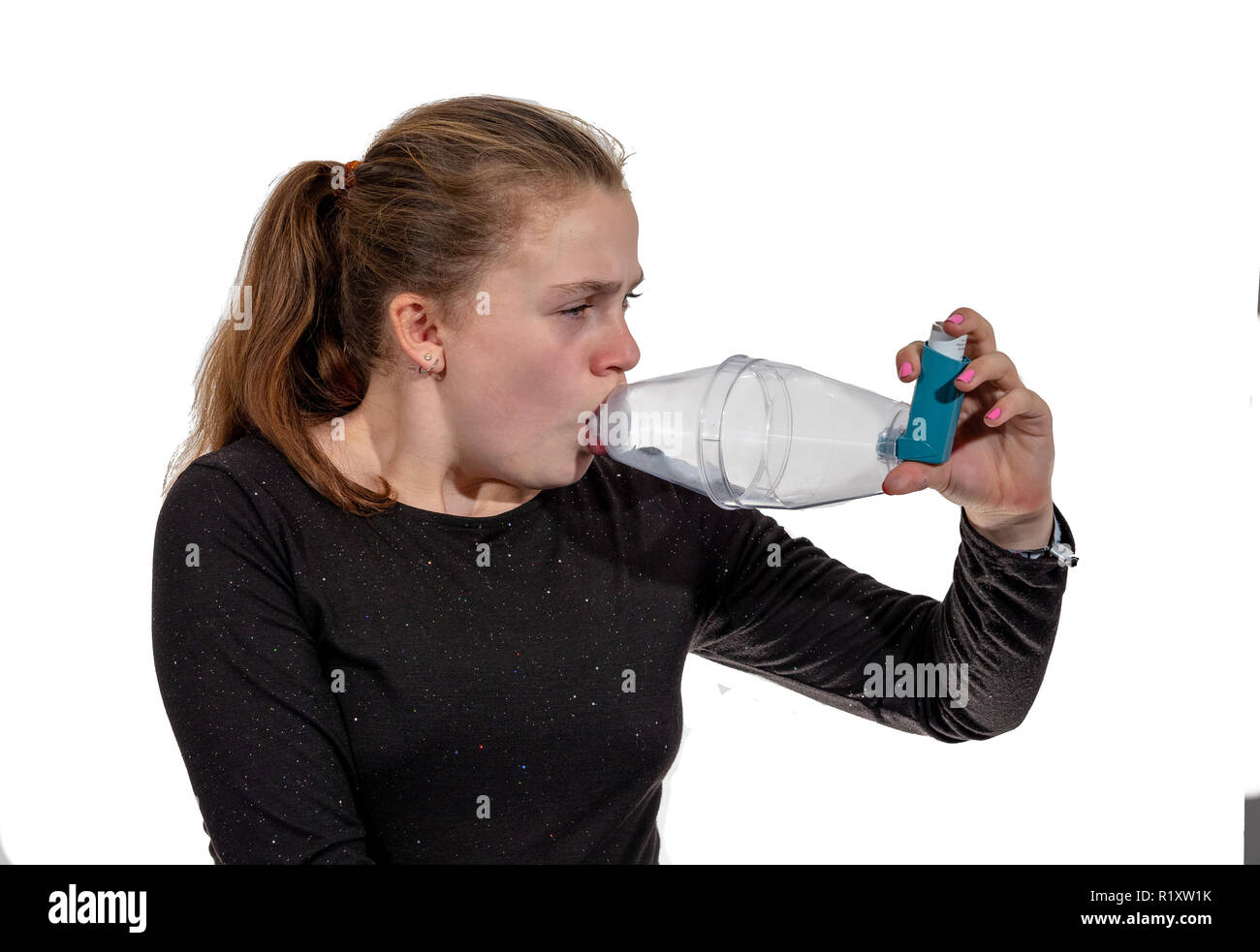 A young girl using an inhaler for asthma Stock Photo