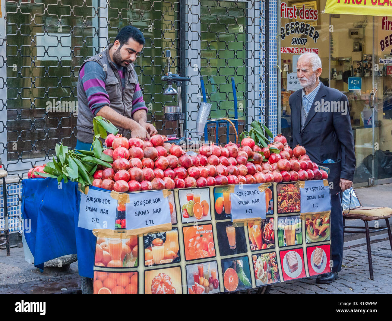 Istanbul, Turkey, November 9, 2012: Turkish man selling pomegranate juice to a customer. Stock Photo