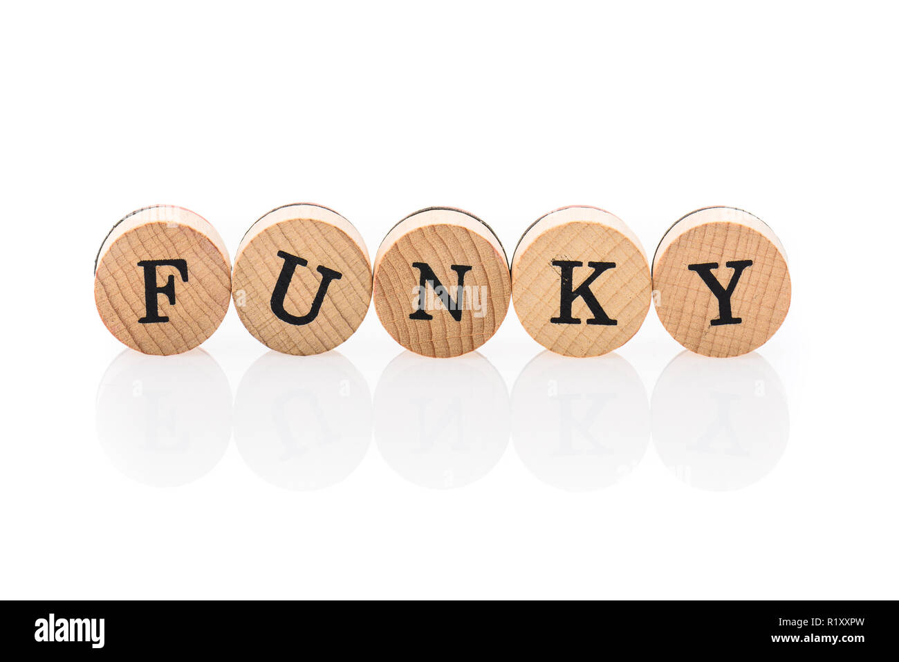Word Funky from circular wooden tiles with letters children toy. Concept of playfulness spelled in children toy letters. Stock Photo