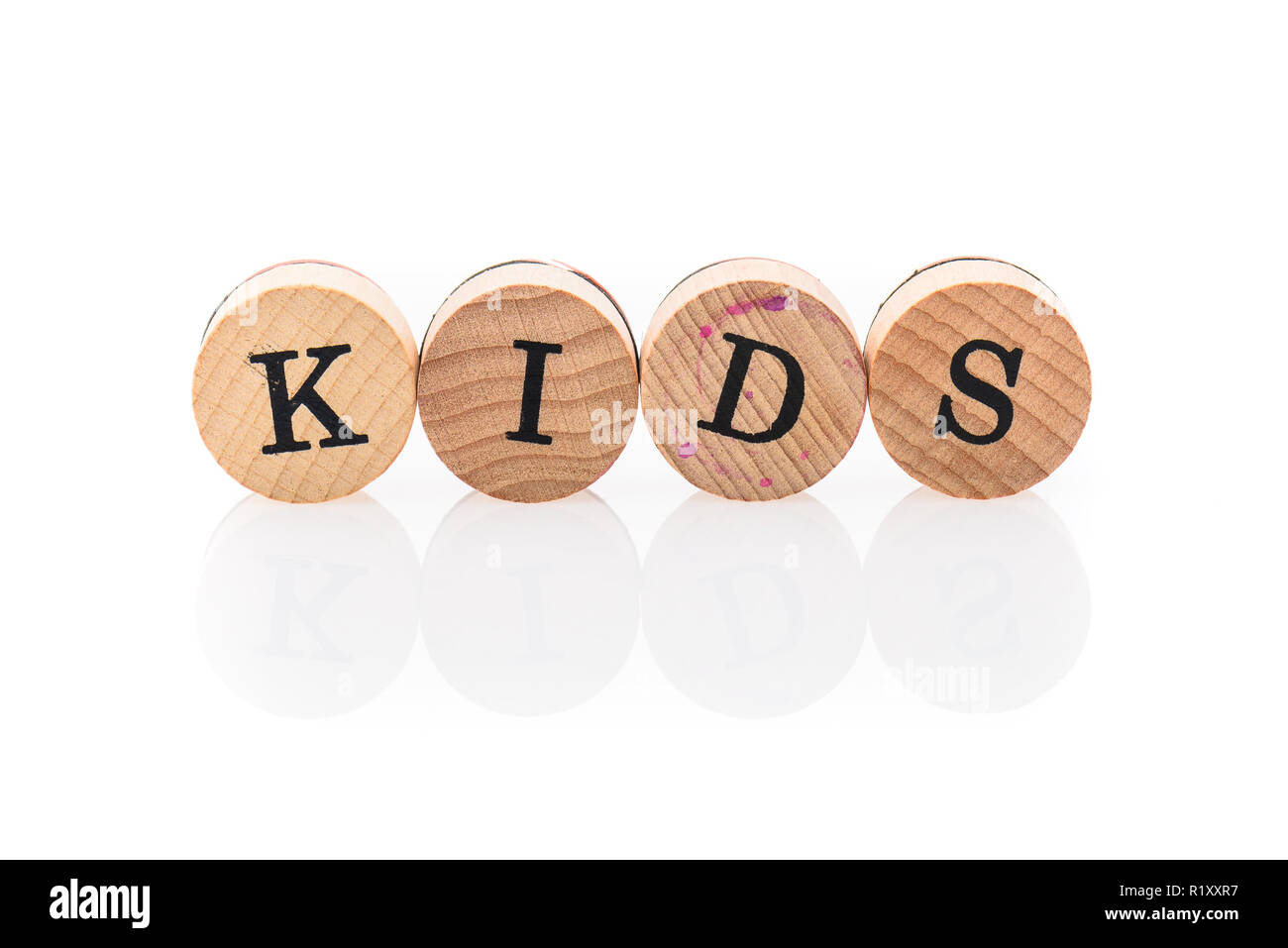 Word Kids from circular wooden tiles with letters children toy. Concept of family spelled in children toy letters. Stock Photo