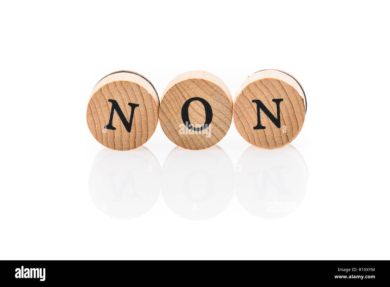 Word Non from circular wooden tiles with letters children toy. Concept of 'absence off' spelled in children toy letters. Stock Photo