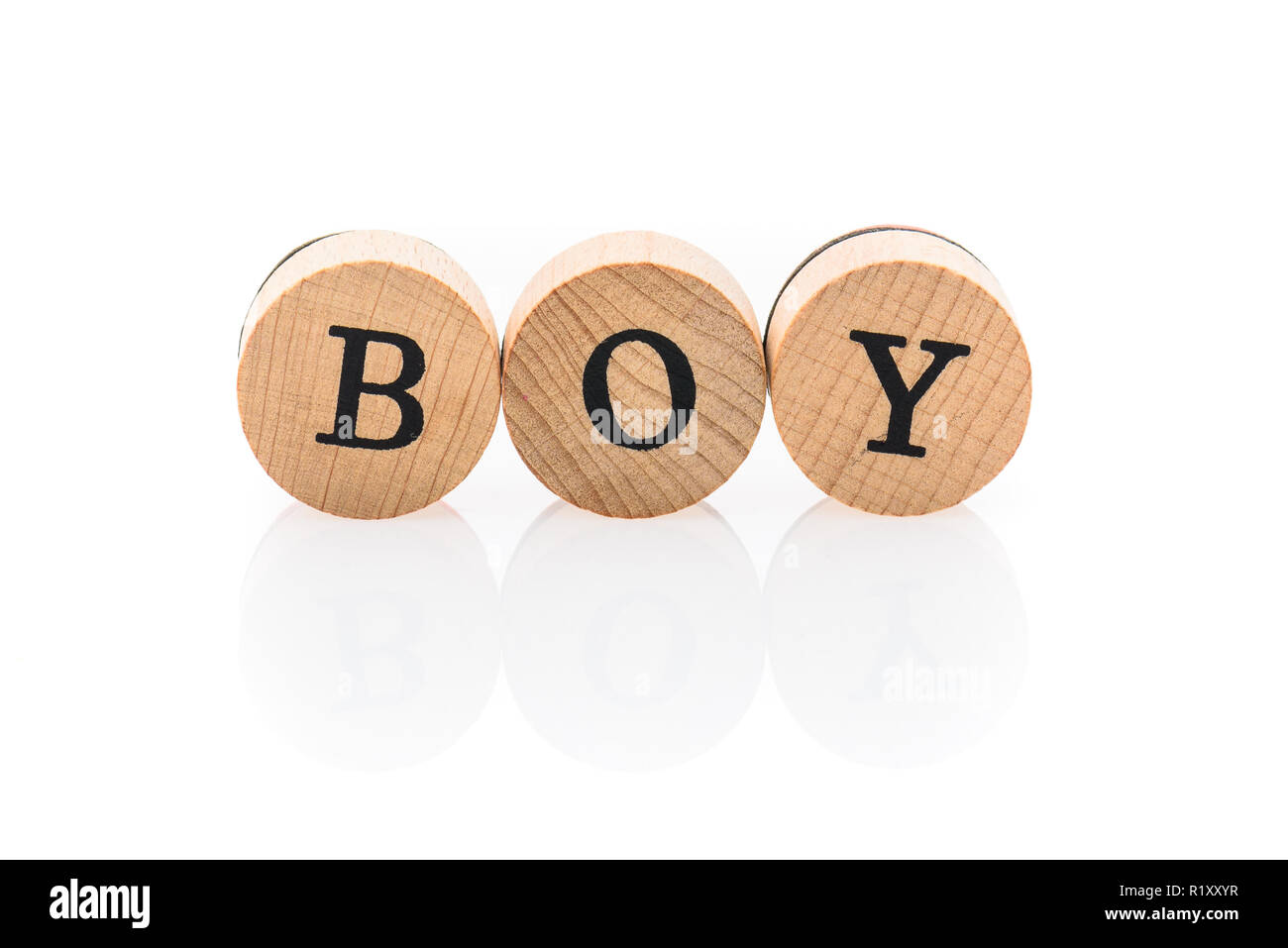 Word Boy from circular wooden tiles with letters children toy. Concept of family spelled in children toy letters. Stock Photo