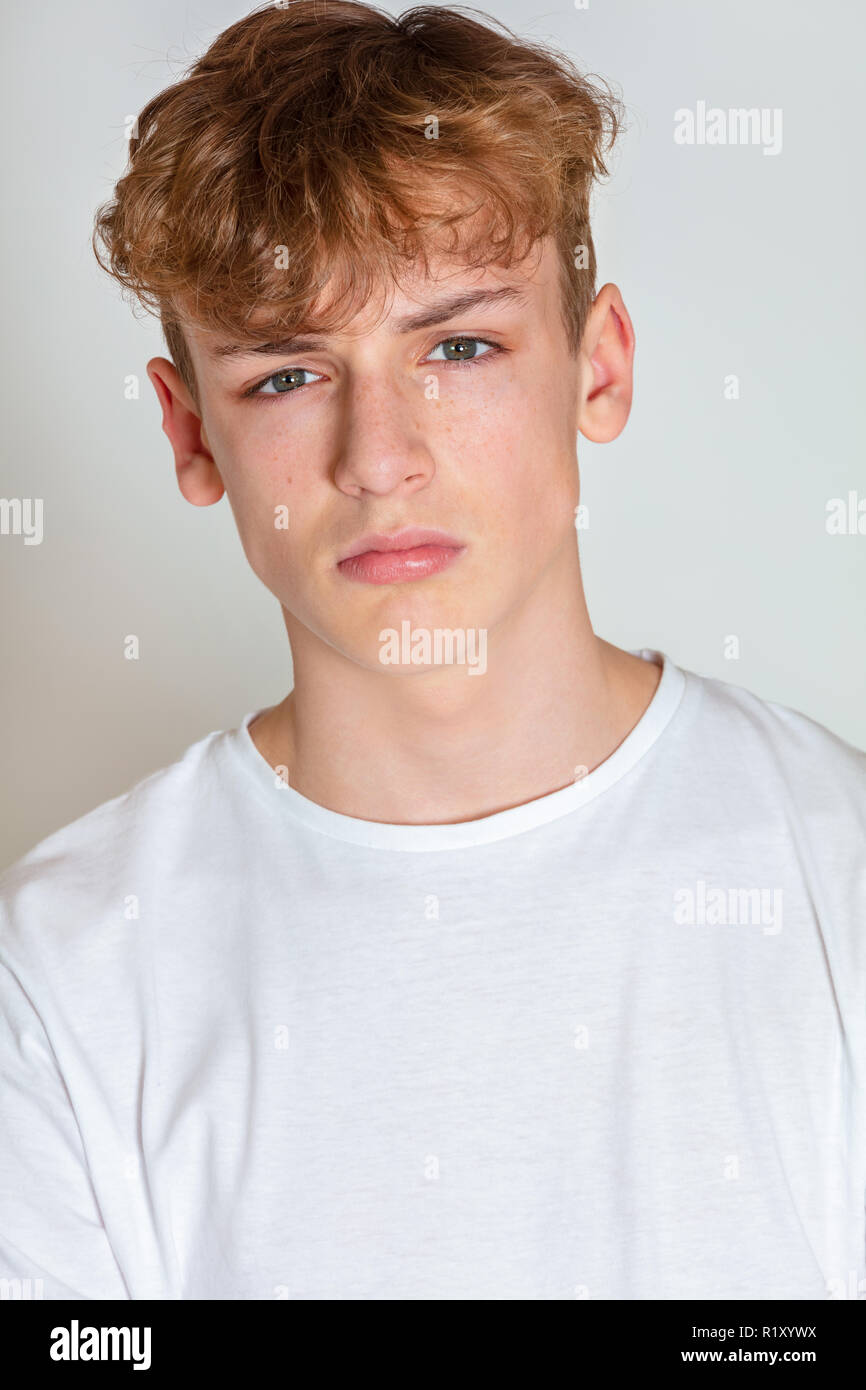 White background studio photograph of young boy male teen teenager young adult looking sad, thoughtful or depressed Stock Photo