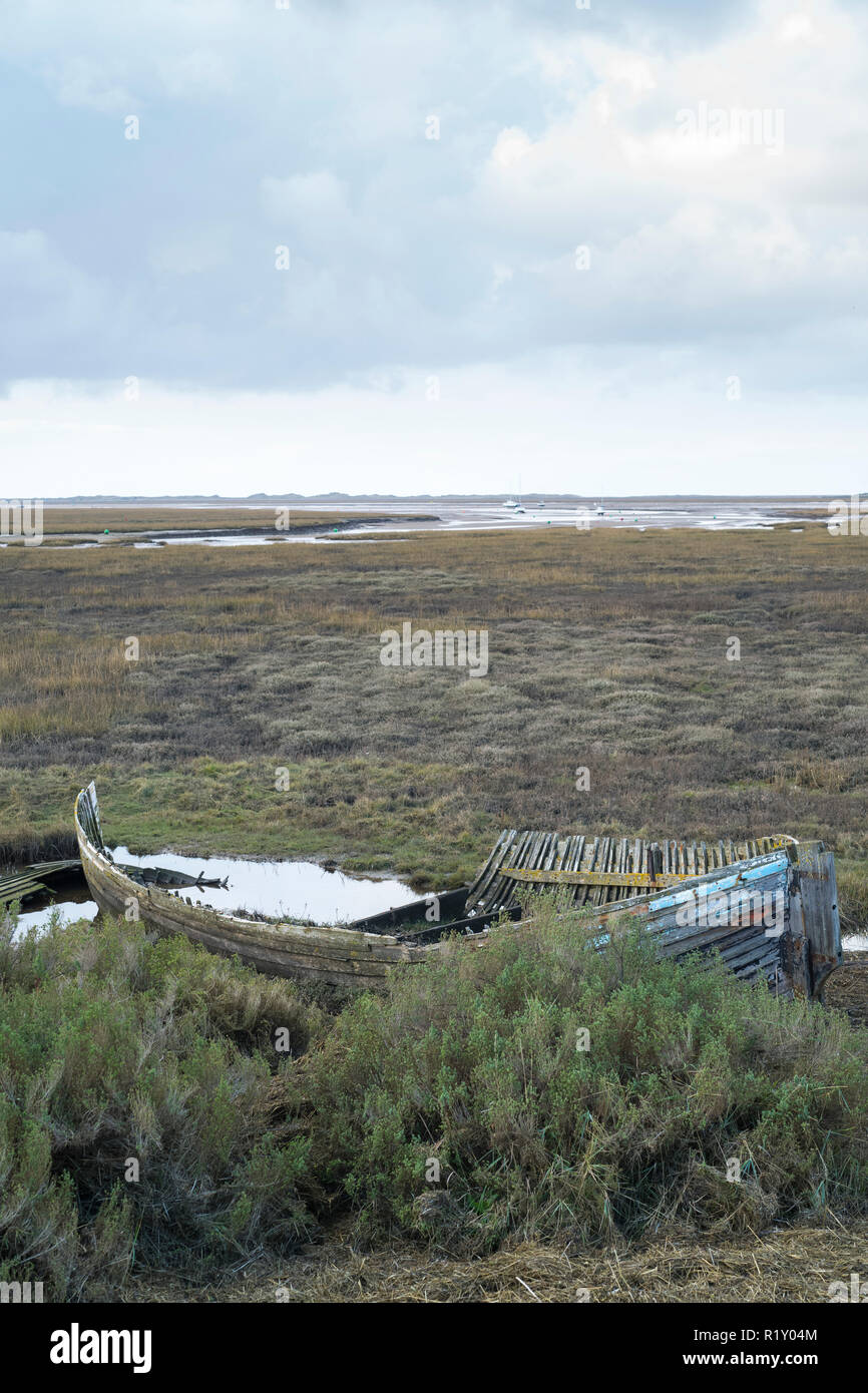 Abandoned derelict shabby sailing boat in marshland at Brancaster Staithe, Norfolk, UK Stock Photo