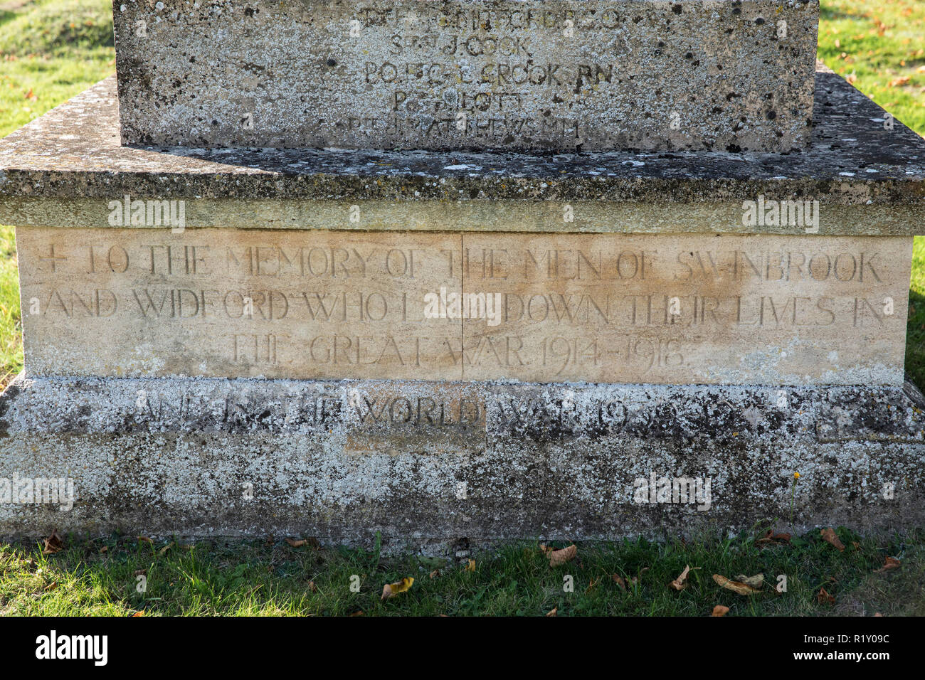Names of soldiers on war memorial for The Great War 1914-1918 - World War I and World War II 1939-1945 alongside graves in traditional graveyard of S Stock Photo