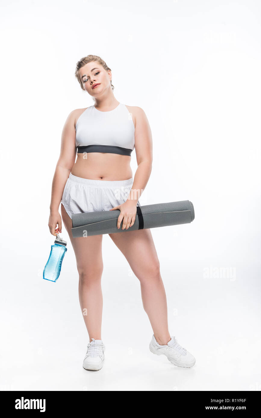sexy woman in sport bra and panties holding sport bottle and looking at  camera isolated on grey Stock Photo by LightFieldStudios