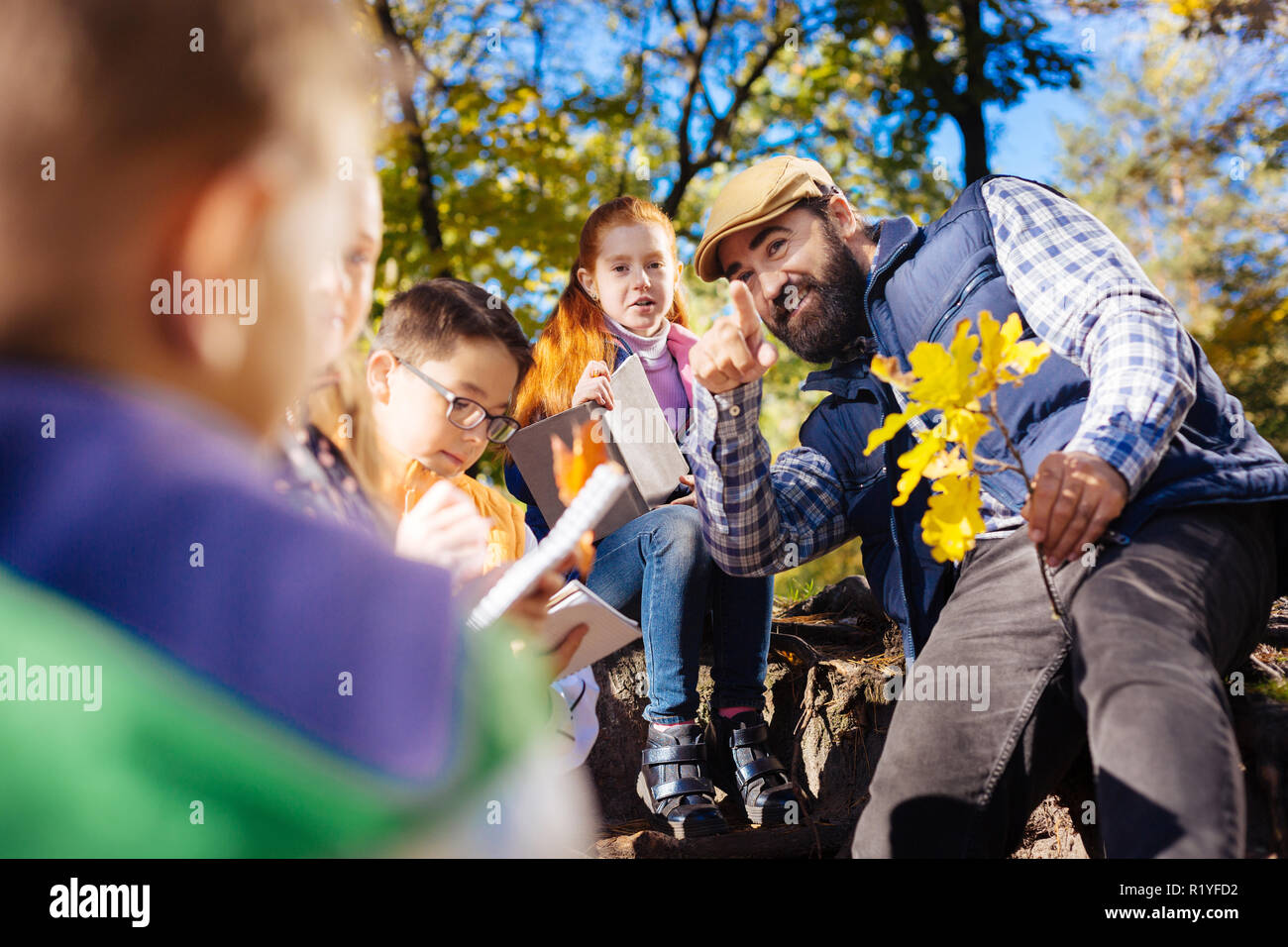 Delighted positive teacher being with his pupils Stock Photo