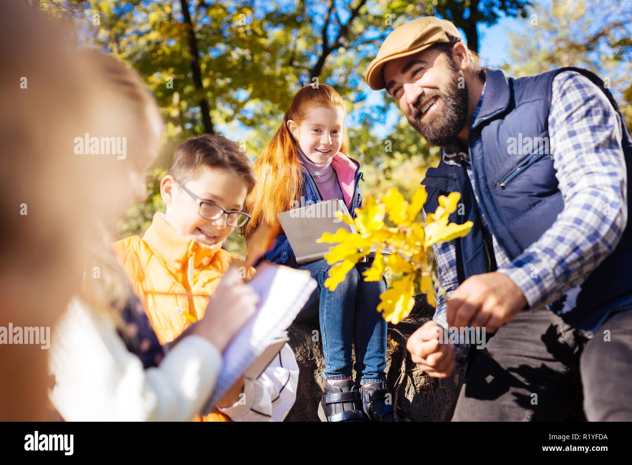 Nice positive man taking children to the forest Stock Photo