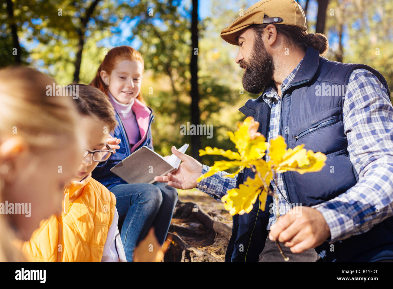 Nice positive man looking at the notes of his pupil Stock Photo