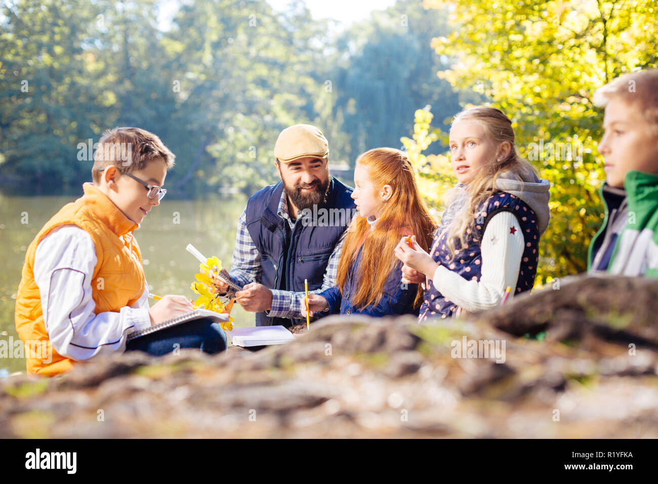 Nice young pupils exploring the forest together Stock Photo