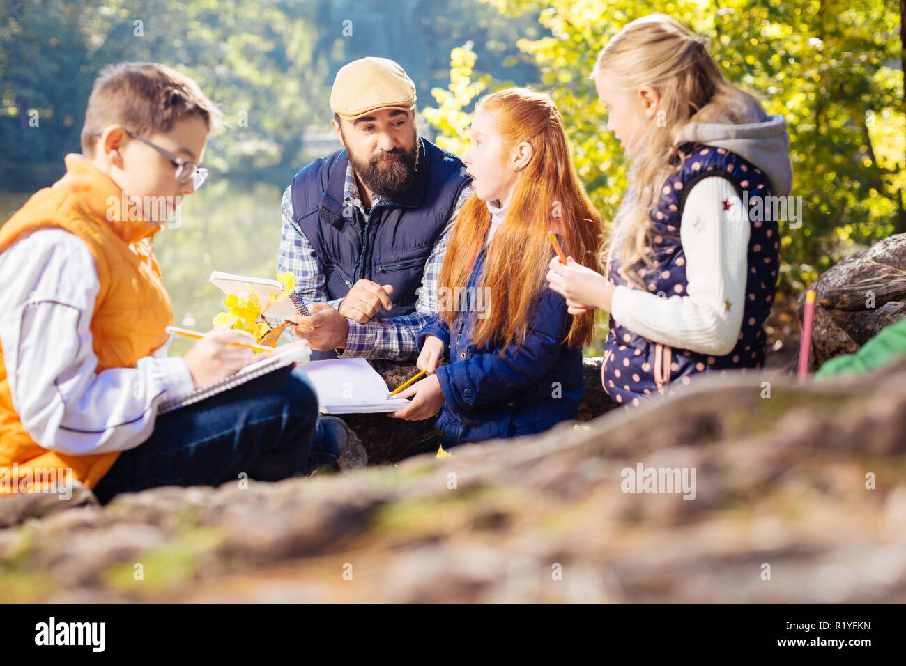 Smart positive kids asking questions to their teacher Stock Photo
