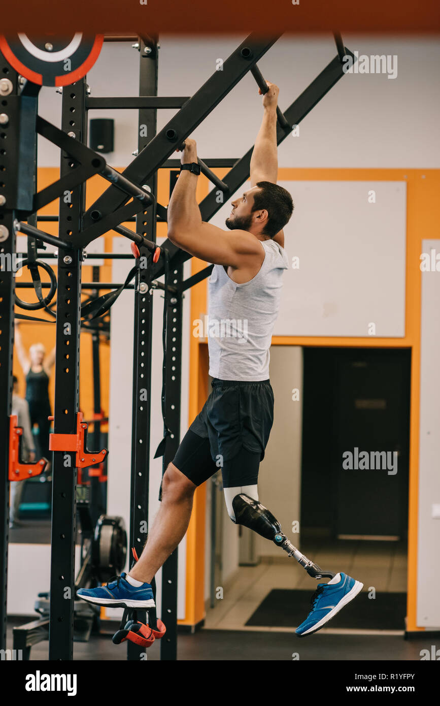 handsome young sportsman with artificial leg working out with
