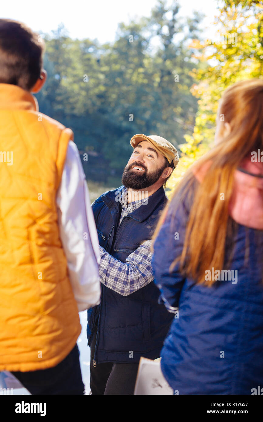 Positive nice man smiling to his young pupils Stock Photo