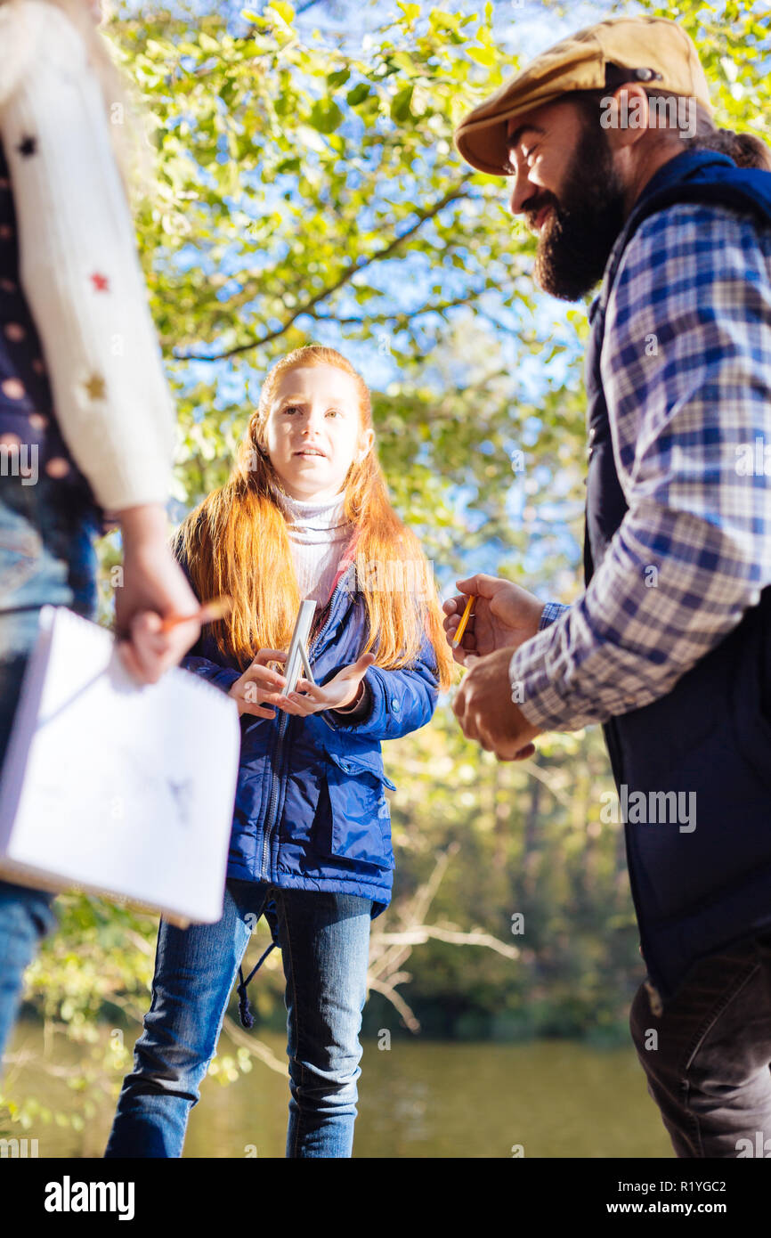 Nice pleasant girl looking at her classmate Stock Photo