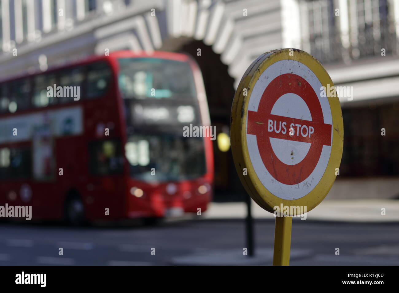 Bus stop sign with red bus on the background. Picture taken on regents street in London. Stock Photo