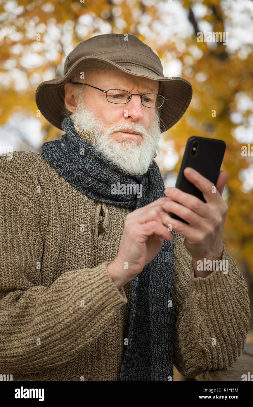 Senior man outdoors using a smartphone Stock Photo