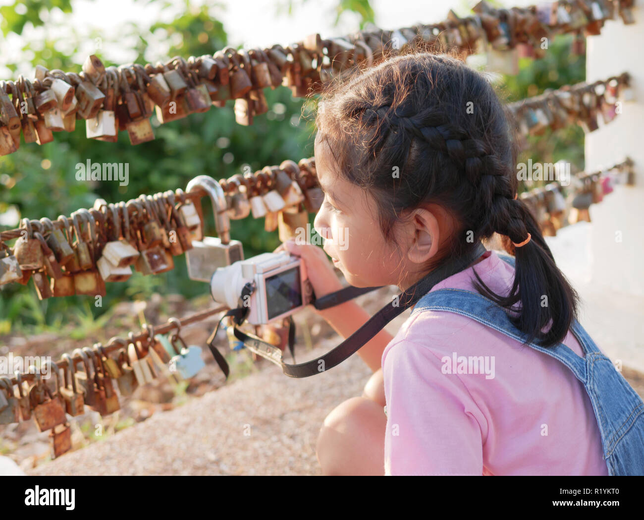 A little girl holding camera with taking a picture. Asian kid making photo travelling. Stock Photo