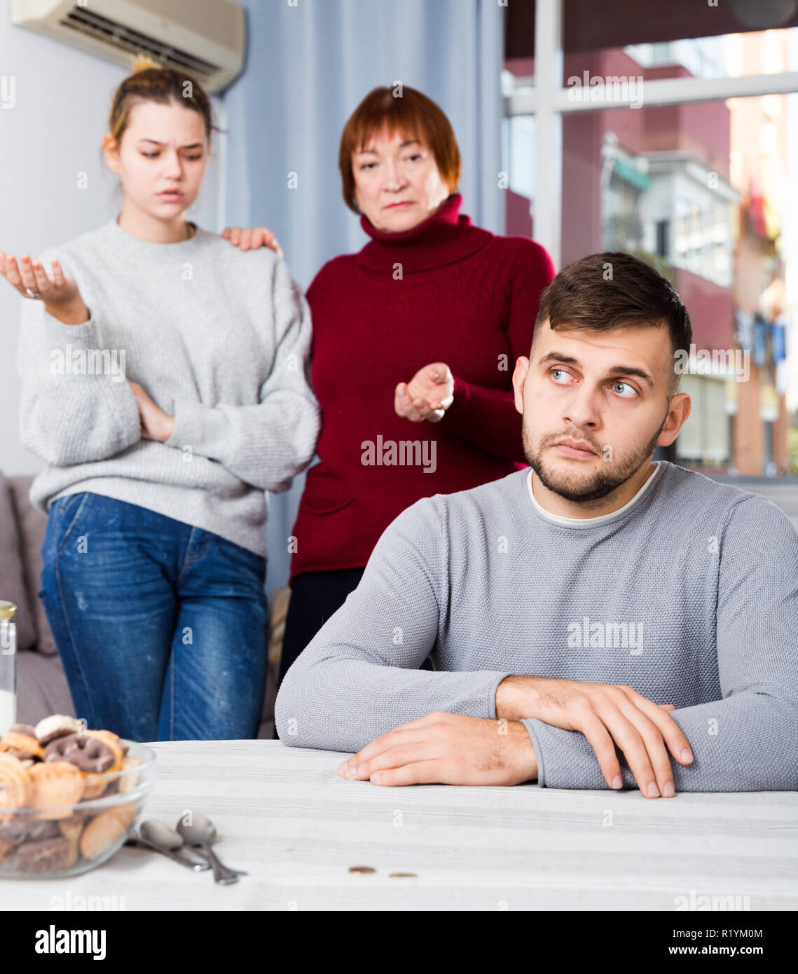 Portrait of chagrined guy sitting separately having problems in ...