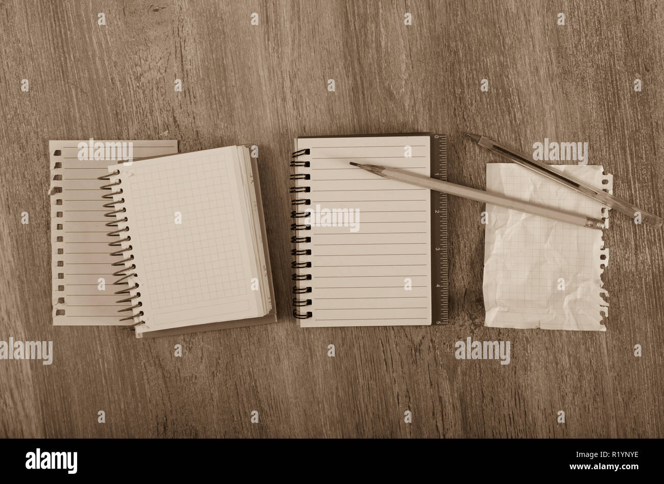 Crumpled empty pages and notebook lying on wooden surface Stock Photo