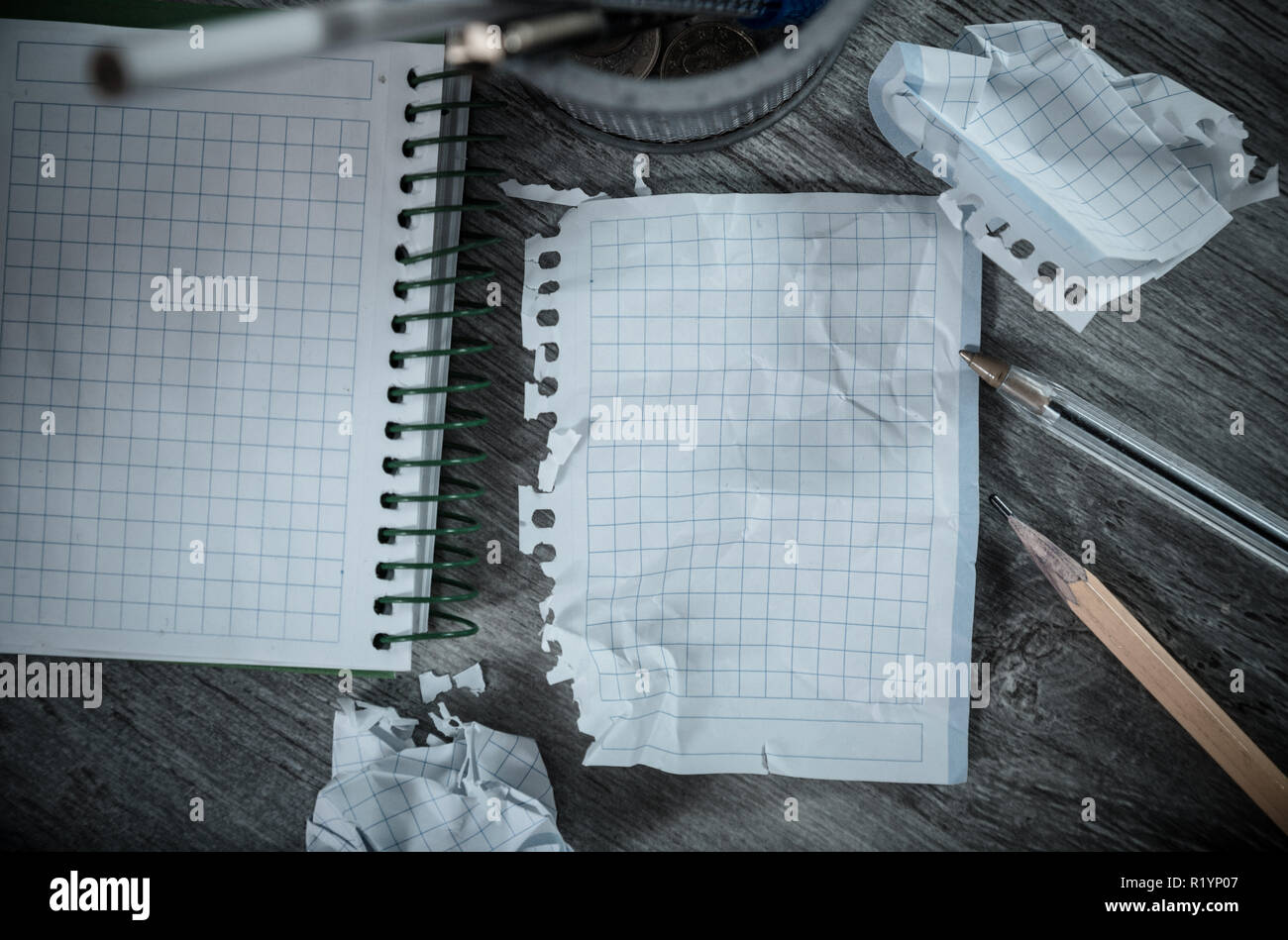 Crumpled empty pages and notebook lying on wooden surface Stock Photo