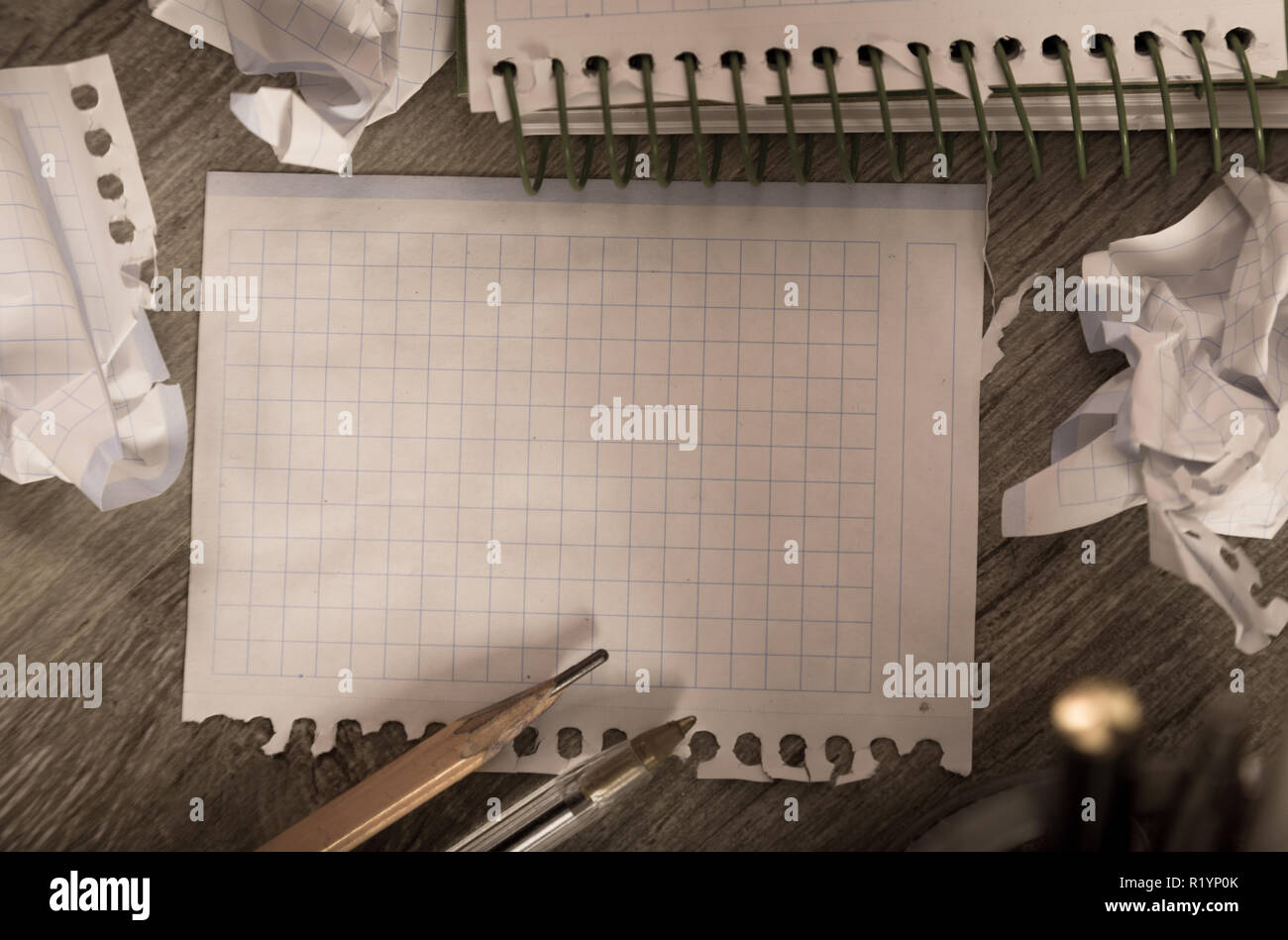 Empty crumpled pages and notebook lying on wooden surface Stock Photo