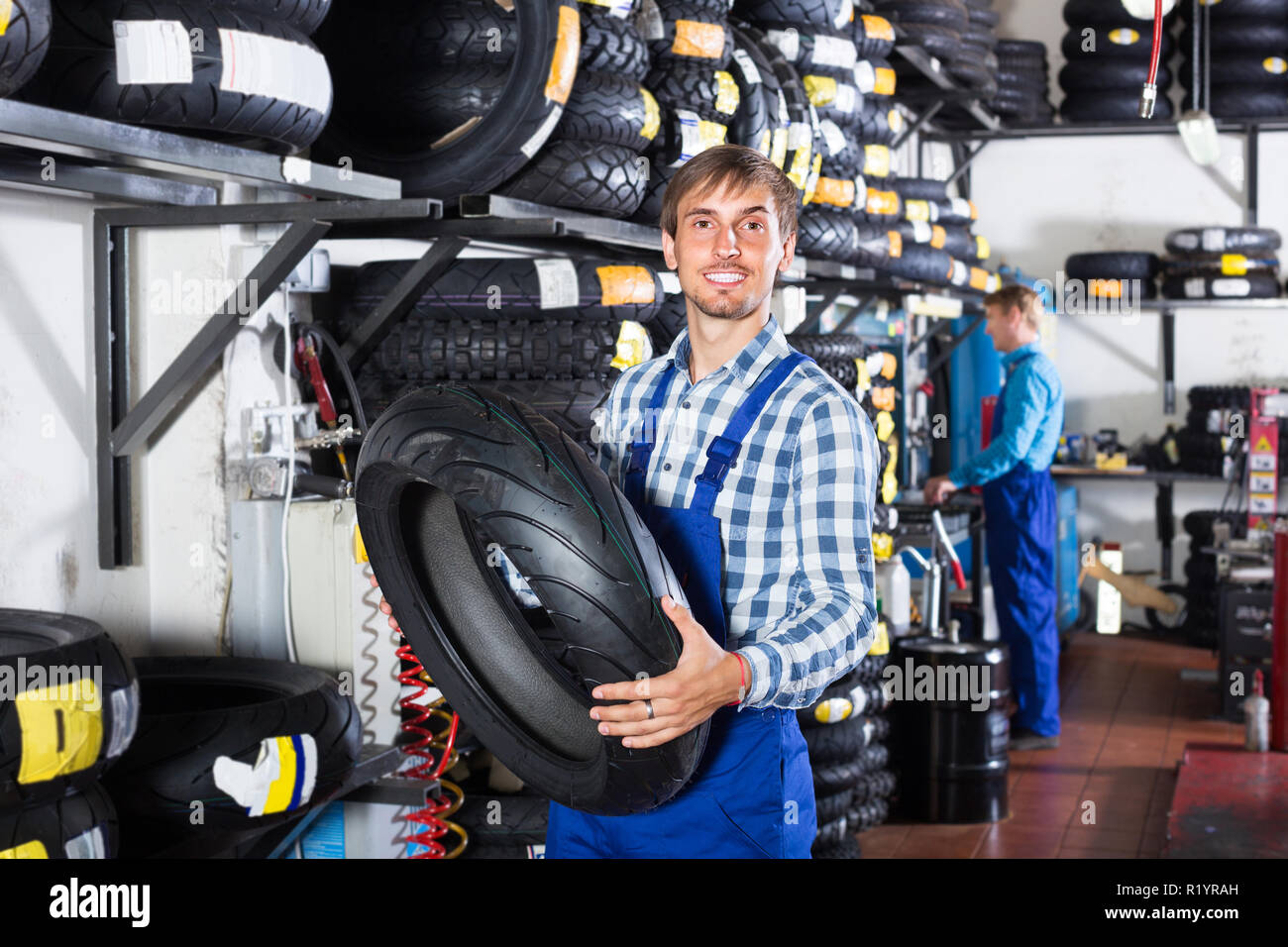 engineer holding new tyre for motorcycle in tire shop Stock Photo Alamy