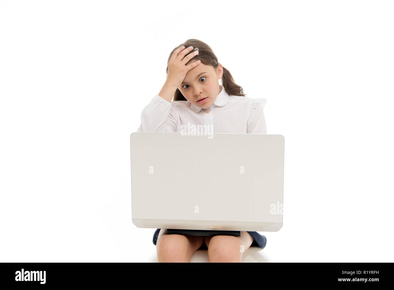 Shocking content. Schoolgirl surfing internet with shocked face. Girl stunned expression touch her head. How can it be possible. Unbelievable news. Surfing internet laptop. Parental advisory concept. Stock Photo