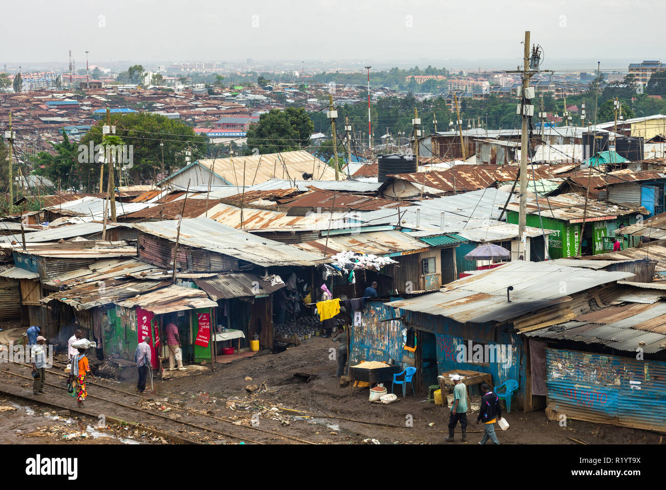 View of a section of Kibera slum showing makeshift shack housing and residents going about daily life, Nairobi, Kenya Stock Photo