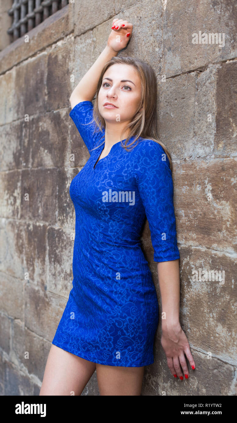Elegant girl is posing in blue dress near old wall on the street Stock ...