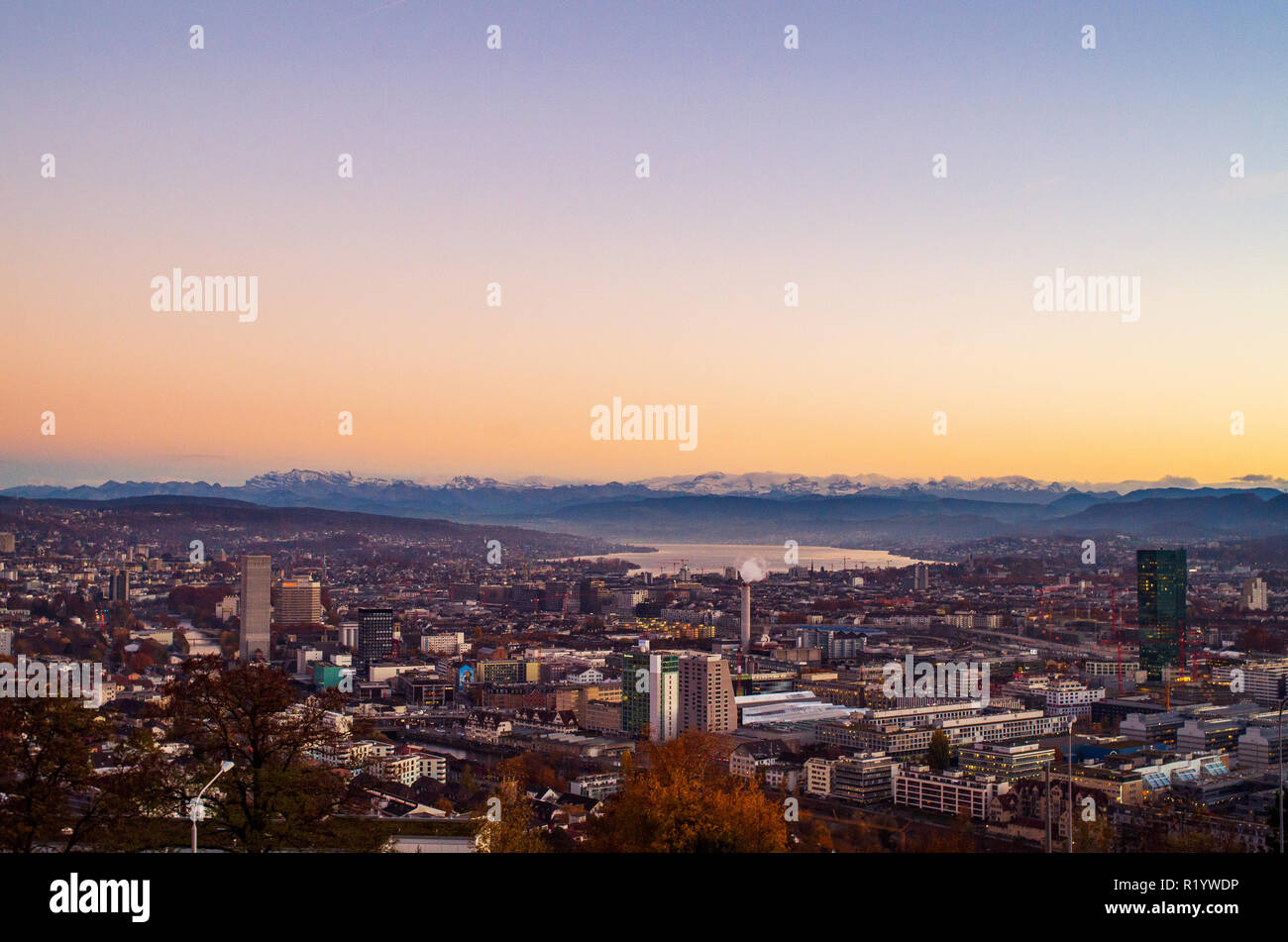 Zurich city vista from atop of Hongg in autumn after sunset before blue hour warm tones Stock Photo