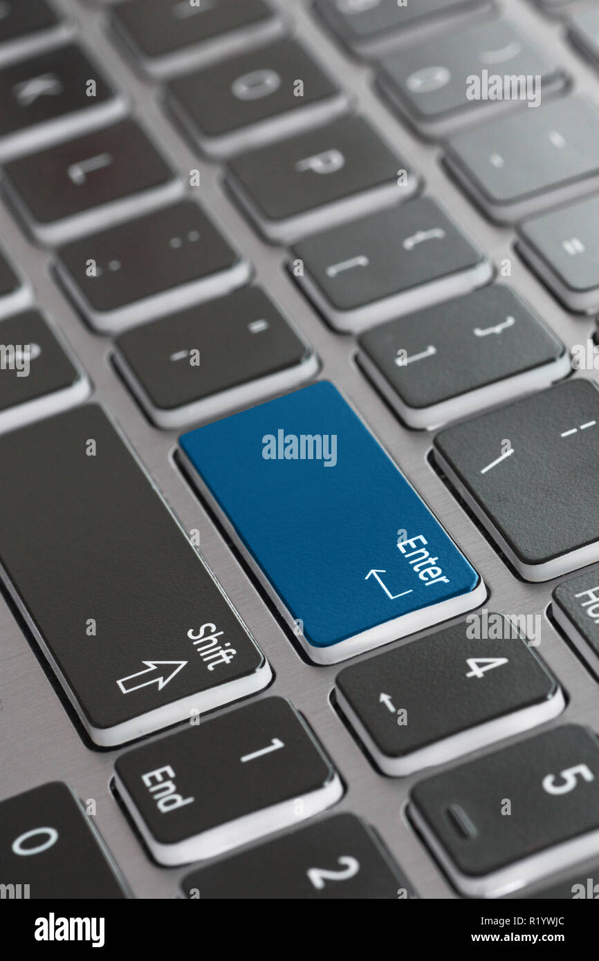 Laptop keyboard macro close up fading enter shift key focused blue enter key Stock Photo