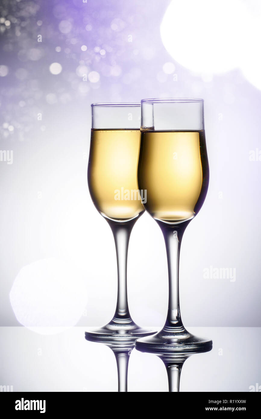 Two elegant glasses with sparkling champagne Holiday card Christmas, New Year, wedding. Celebration concept with effects of selective focus on bokeh, falling snow, advertising design Stock Photo