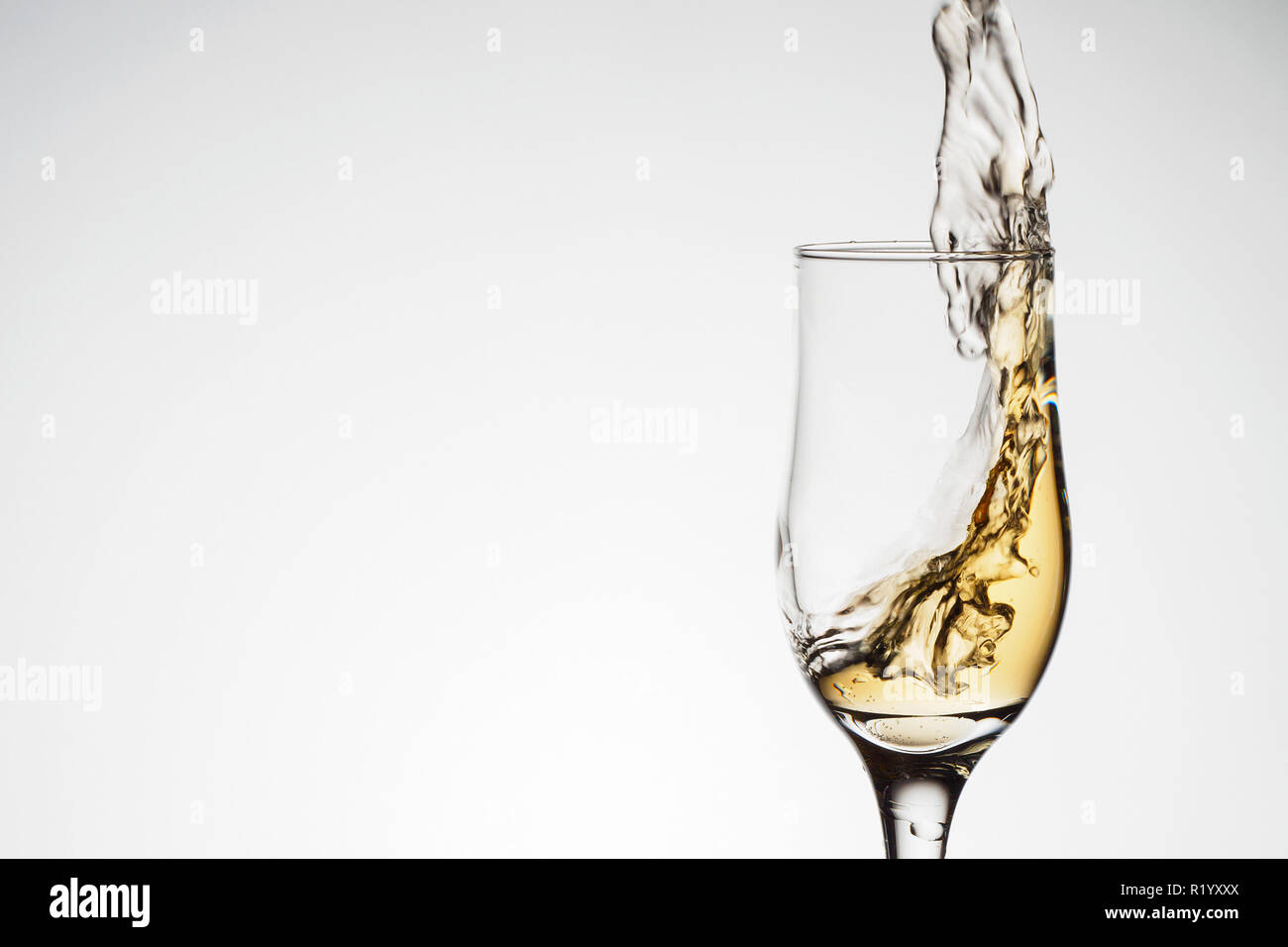 One elegant glass with sparkling champagne with splash. Holiday card Christmas, New Year, wedding. Celebration concept advertising design Stock Photo