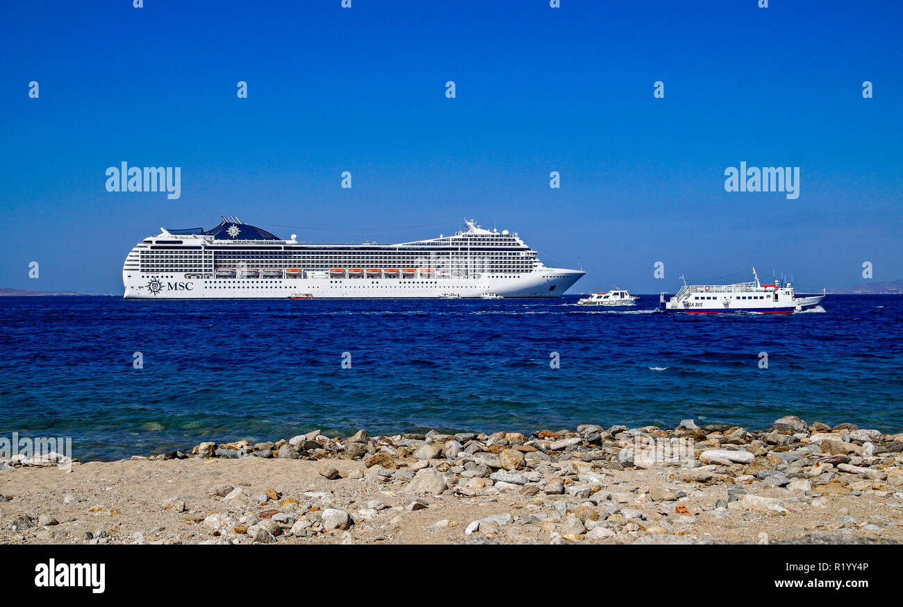 MSC cruise liner Poesia at anchor outside Mykonos town on island Mykonos in the Cyclades group in the Aegean Sea Greece with Seabus Margarita ch right Stock Photo