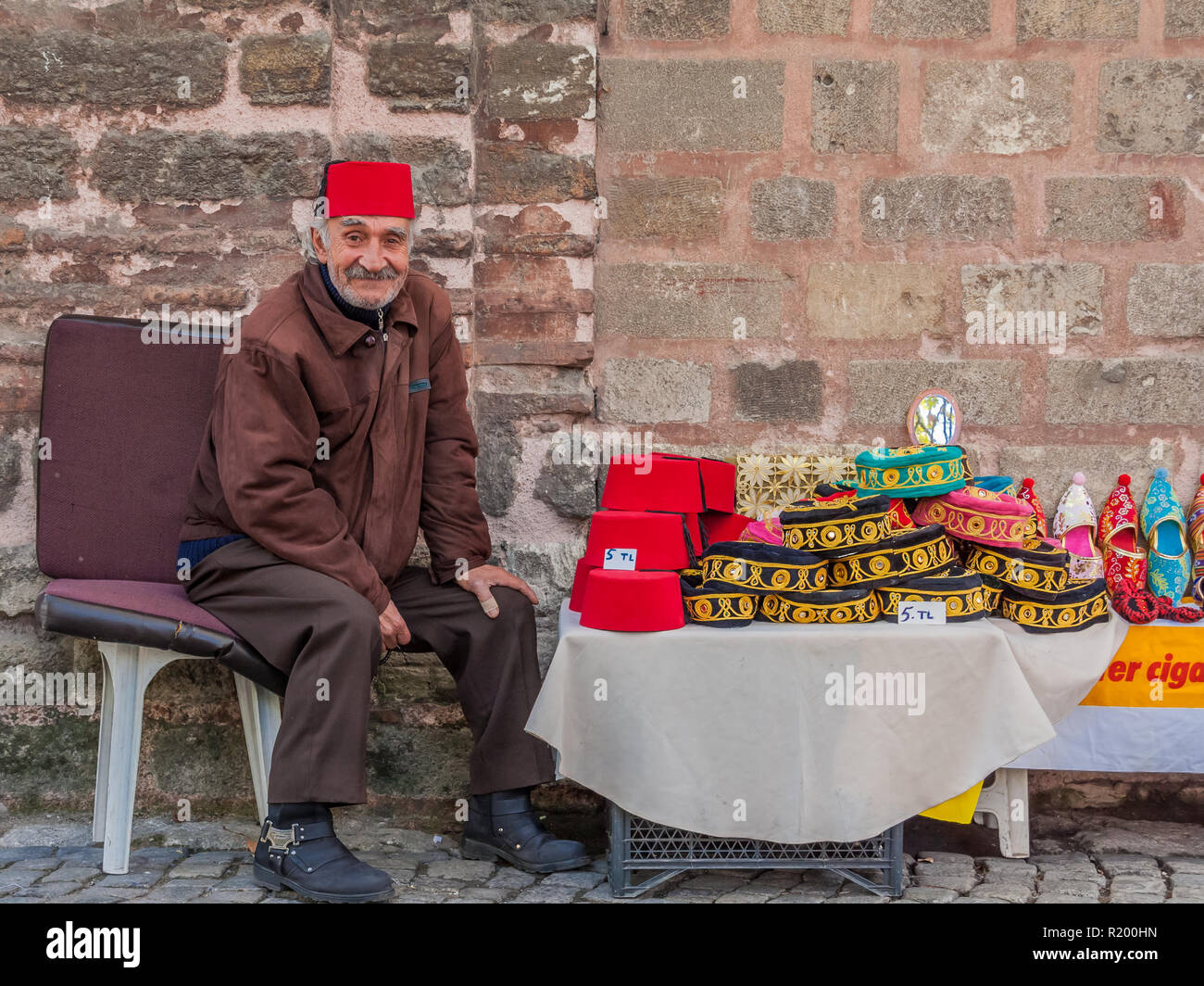 Istanbul, Turkey, November 13, 2012: Turkish man selling Turkish hats outside the Chora Museum in Balat. Stock Photo