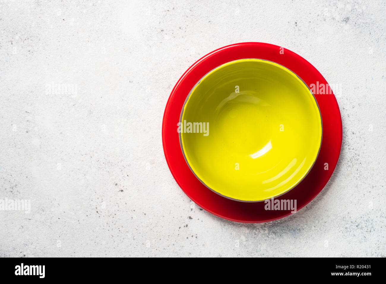 Colored dinnerware red and green plates on light stone table Stock Photo Alamy