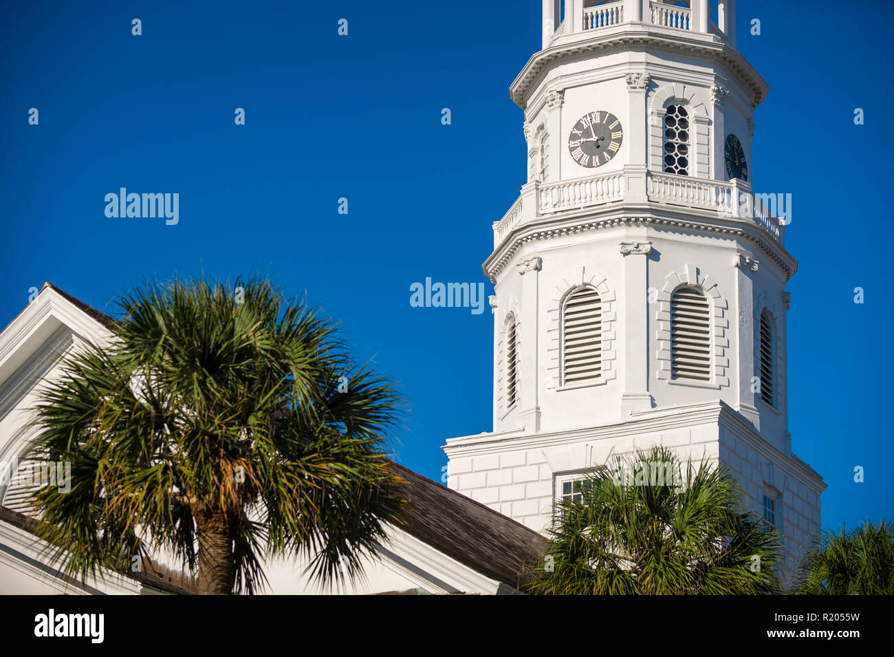 Sunny scenic detail view of classical Southern church architecture with palmetto palms under bright blue sky in Charleston, South Carolina, USA Stock Photo