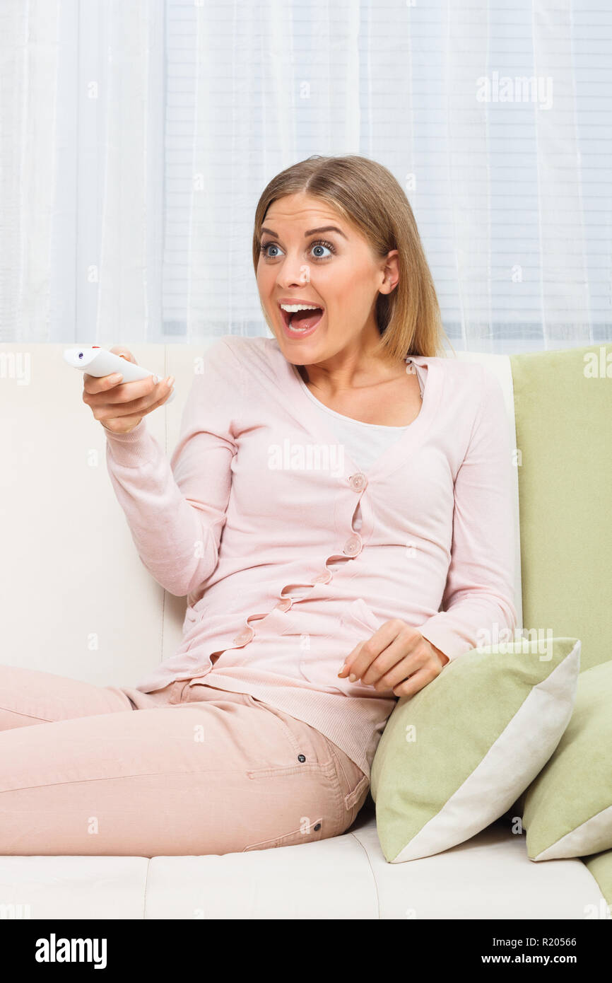 Surprised woman watching tv Stock Photo - Alamy