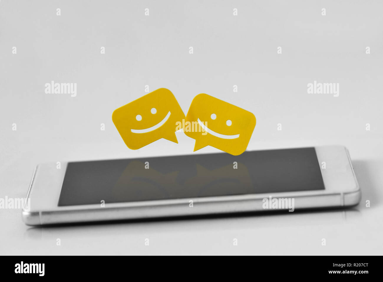 Smartphone with chat message bubbles on white background Stock Photo