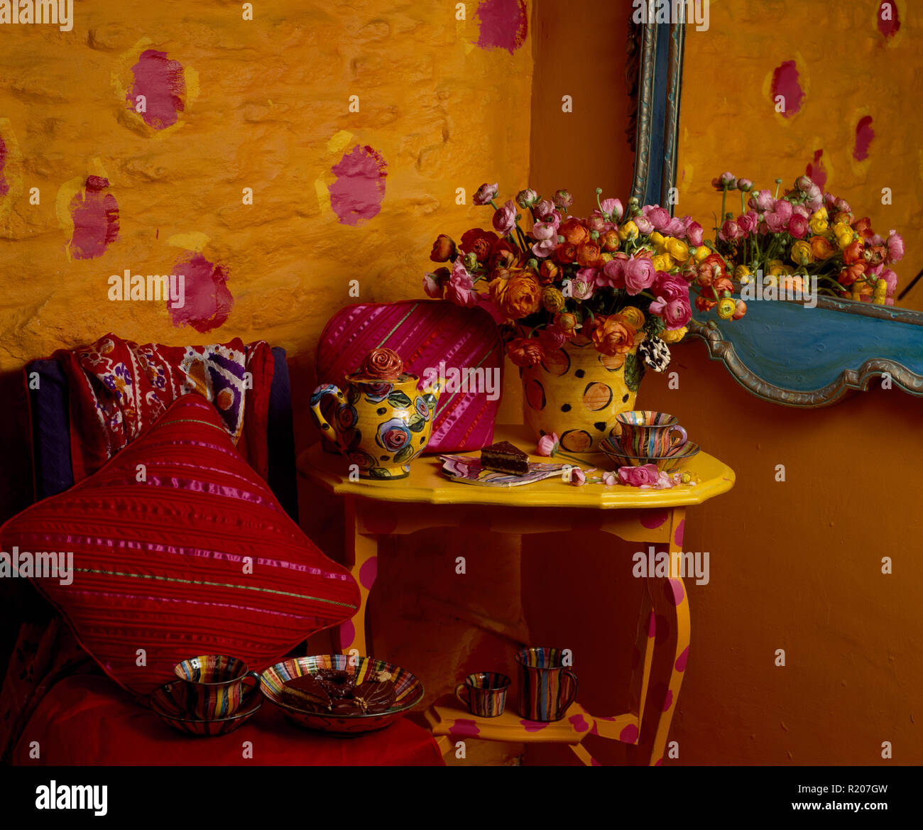 Colourful pottery on a yellow painted side table Stock Photo