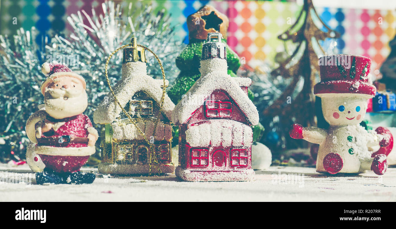 Santa Claus, snowman, houses & snow Sledge miniature model studio shot on colorful background for family, giving, season, Christmas, holiday, new year Stock Photo