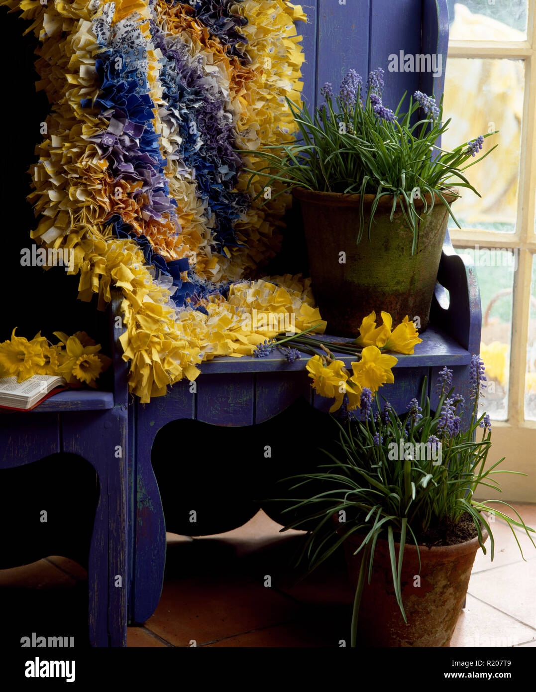 Yellow and blue rag rug on painted settle Stock Photo Alamy