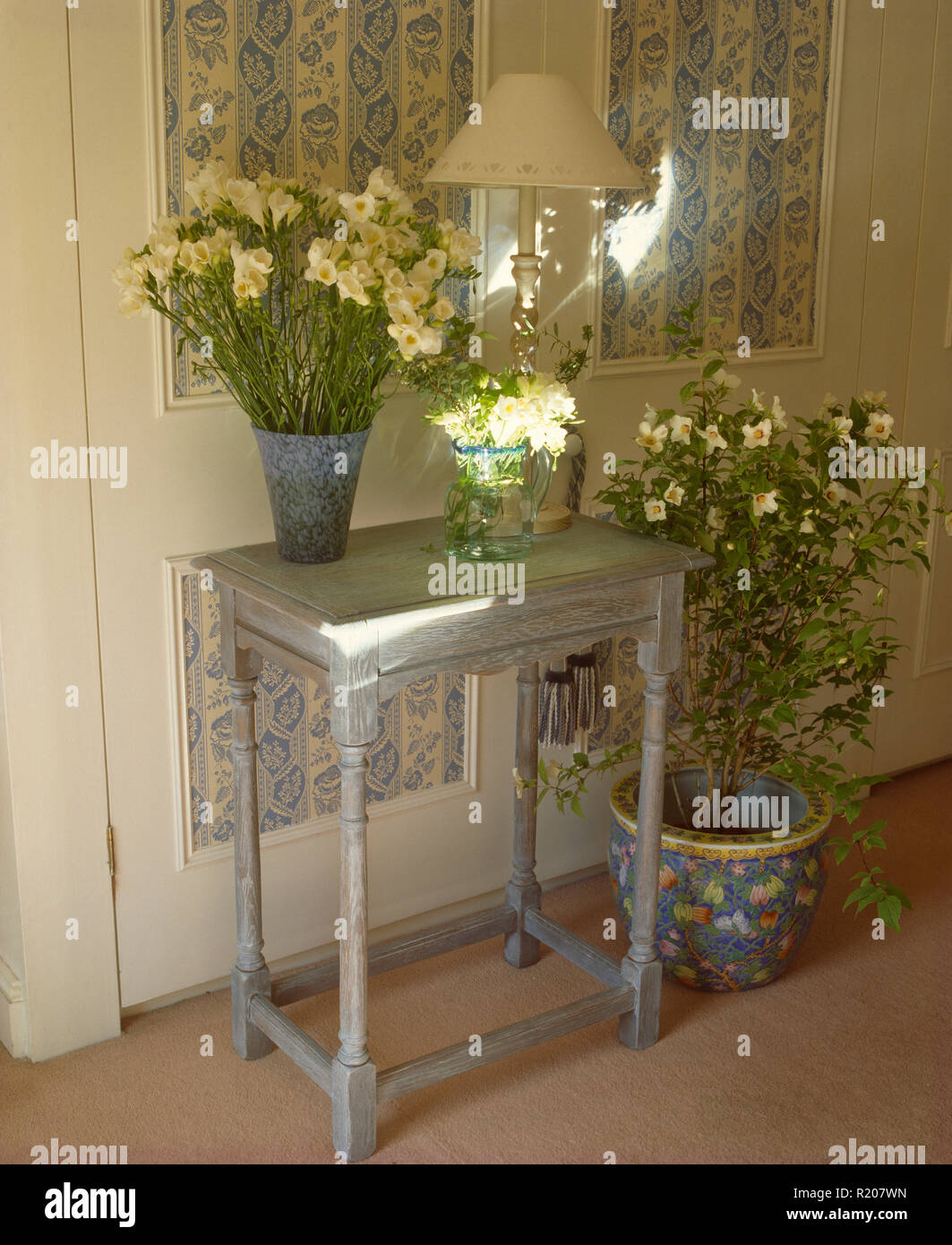 Vase of white flowers on painted console table Stock Photo Alamy