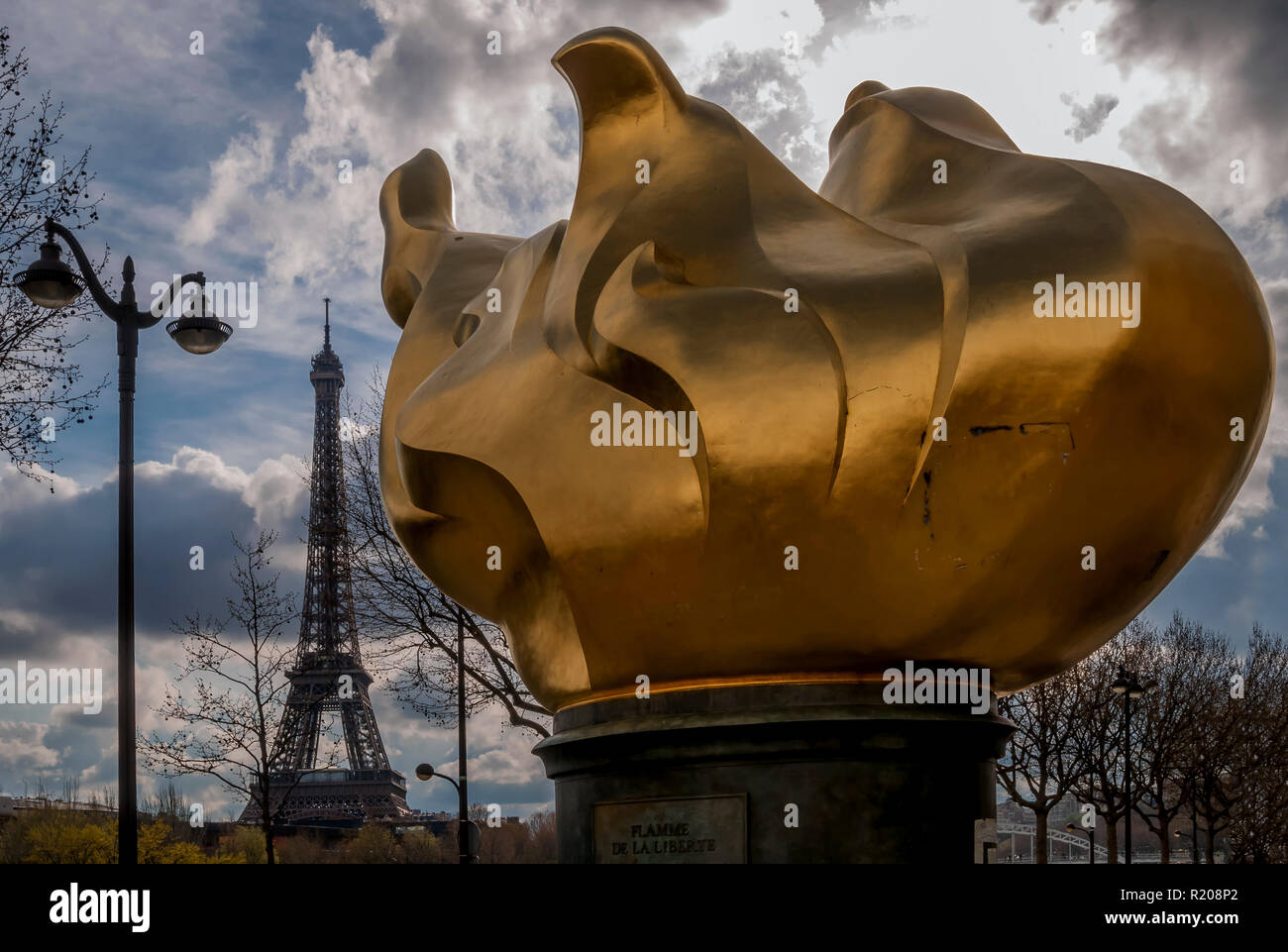 The famous flame of liberty with the Eiffel Tower in the background and a dramatic sky, Paris, France Stock Photo