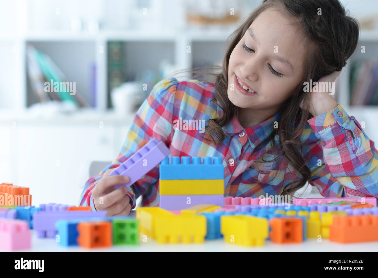 Little girl playing with colorful plastic blocks Stock Photo - Alamy