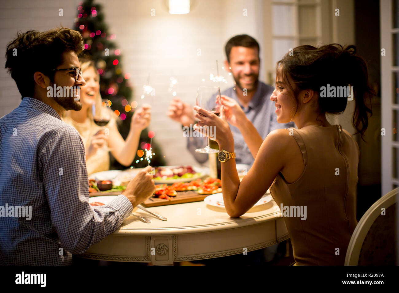 Young friends celebrating Christmas or New Year eve at home Stock Photo